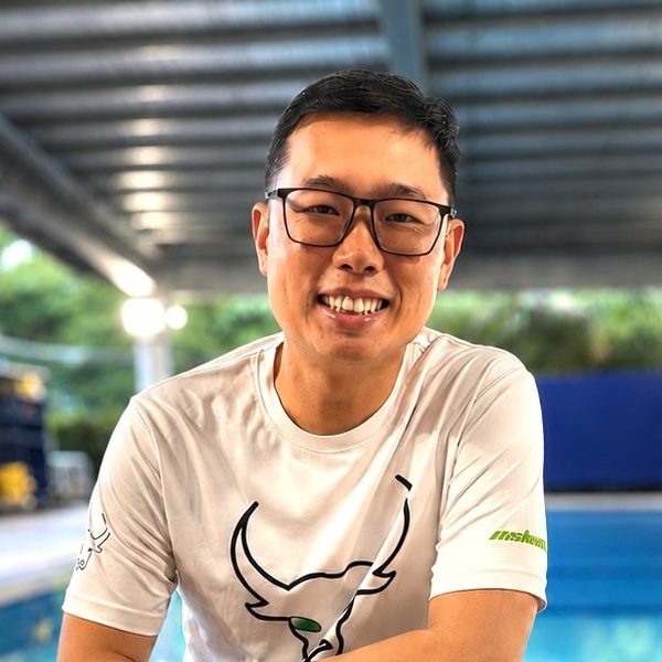 Coach Ethan smiling at the poolside